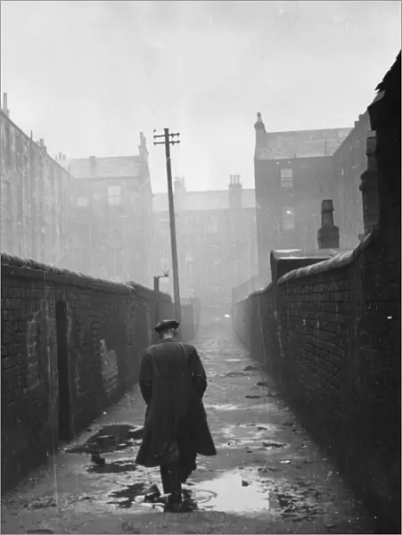A man walking through a backstreet of the Gorbals area of Glasgow