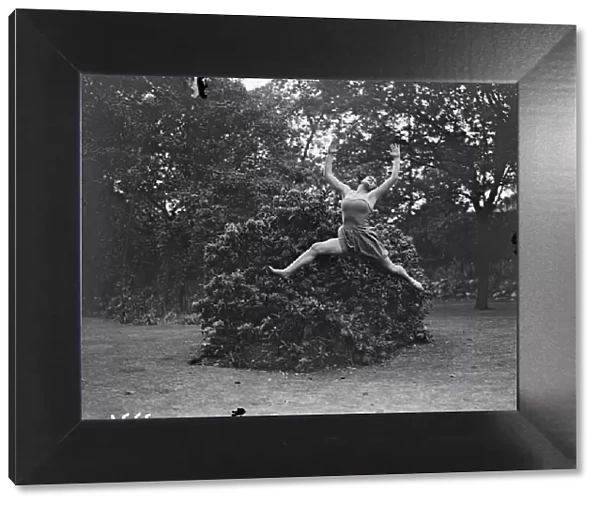 Dancing Dryad, a tunic clad Margaret Morris dancer leaping barefoot over the grass