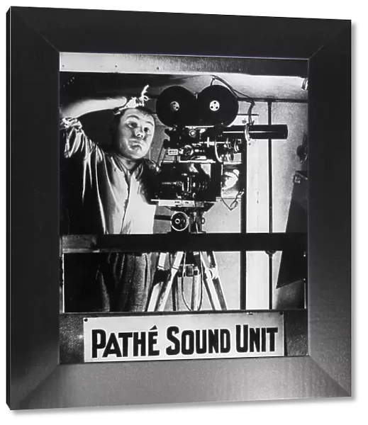 Phew !. circa 1930: A camera operator in a Pathe News studio in London is suffering