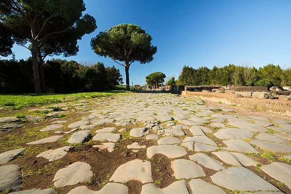 An ancient Roman road in the ruins of the Ancient Roman harbour city of Ostia Antica in Rome, Italy