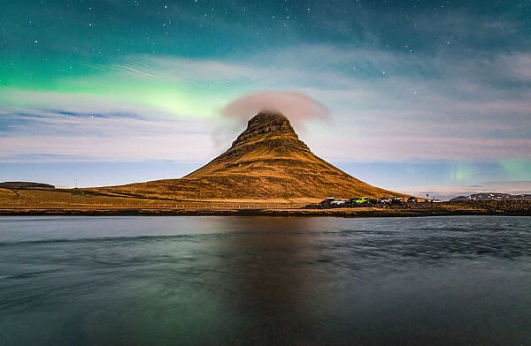 Aurora borealis and cloud cap over the Kirkjufell mountain the iconic landmark of west Iceland
