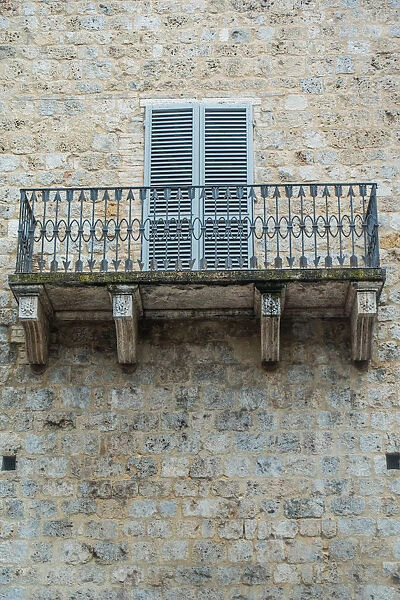 Balcony. Stone building and wrought iron balcony with pattern of arrows