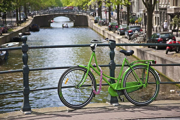 Bicycle on a bridge crossing a canal in the historic city centre of Amsterdam, Holland, Netherlands, Europe
