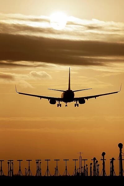Boeing 737 aircraft landing at an airport at sunset, Stansted, Essex, England, United Kingdom