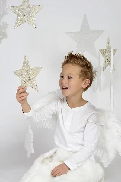 Child, boy wearing an angel costume with stars, Christmas, festive season