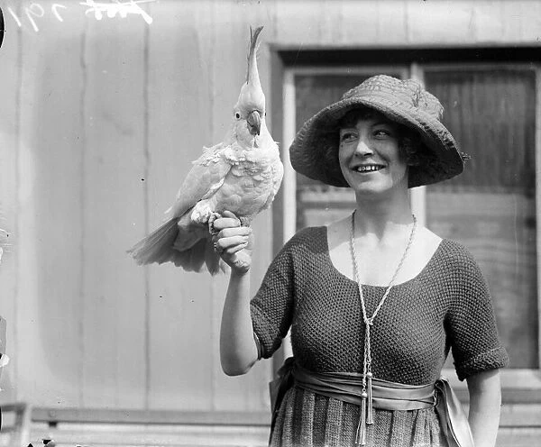 Cockatoo. circa 1926: A woman with a cockatoo perched on her hand