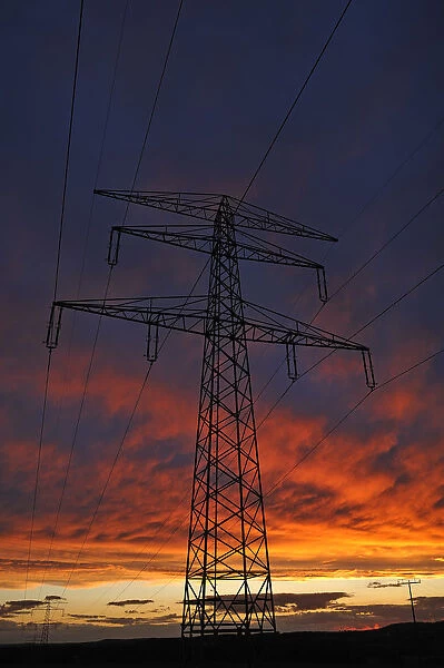 Electricity pylon against a red evening sky, Bavaria, Germany
