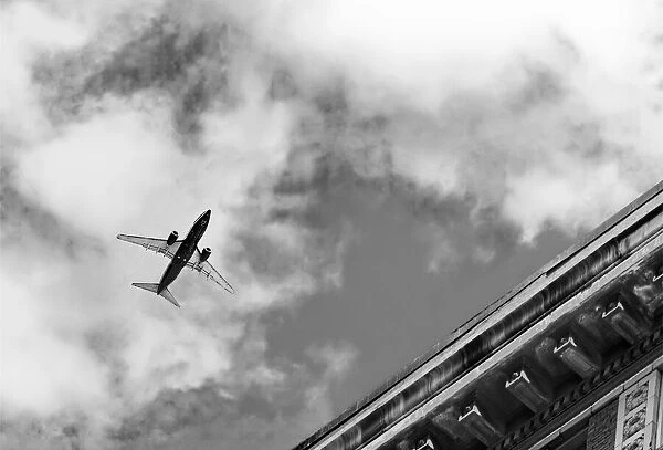 Flyover. A black and white photograph of a commercial jetliner flying over