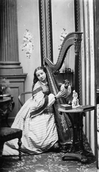 A Harpist. circa 1890: A harpist playing her instrument. (Photo by Rischgitz / Getty Images)