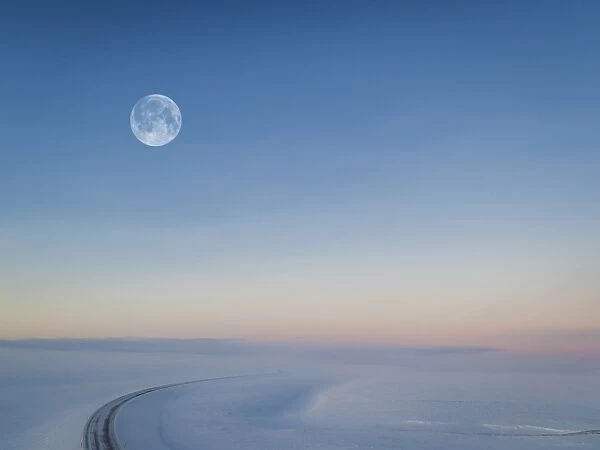 Moon over snowy road, Iceland