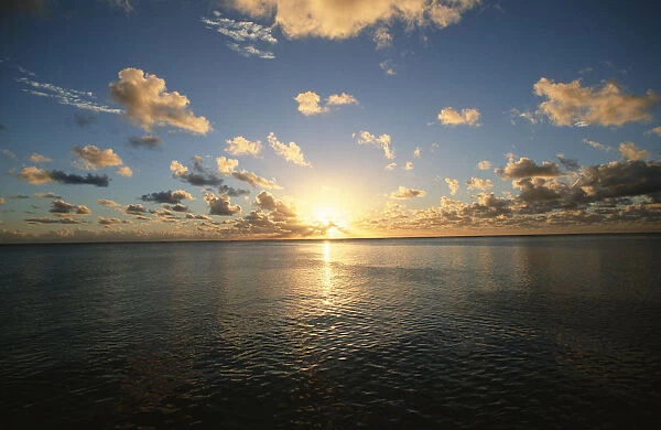 Scenic View of the Sun Setting over the Calm Ocean