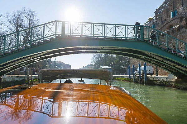 Taxi boat on Grand Canal and old bridge reflected on the boat roof in Venice, Italy