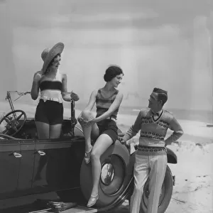 2 Women Bathing Suits Posed On Convertible Car With Man In Striped Trousers And Vest Looking On Upscale Fashion Wealth Leisure Straw Hat