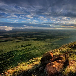 Dramatic Sunset from the edge of a cliff over the Magaliesberg Mountain Range looking towards the flat agricultural North-West Province of South Africa. Magaliesberg Mountains, North-West Province, South Africa