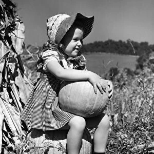 Girl sitting on pumpkin, wearing sun bonnet