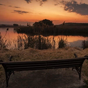 Lonesome bench landscape at sunset on the shore of a remote farm lake, Magaliesburg, Gauteng Province, South Africa