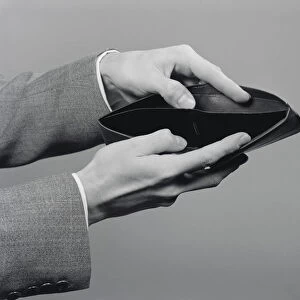 Mans hands holding open empty wallet. (Photo by H. Armstrong Roberts / Retrofile / Getty