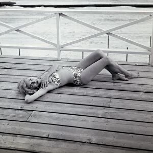 Portrait of young woman in bikini lying on deck
