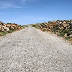 Rocks lining a straight country road at Cap de Cavalleria, Cap de Cavalleria, Menorca, Balearic Islands, Spain