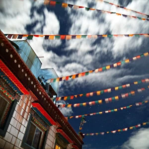 Tibetan prayer flags fly in night sky over house
