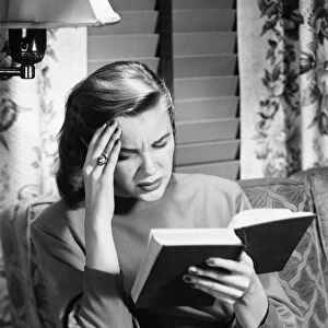 Woman reading book, touching forehead, (B&W)