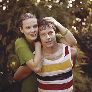 Young woman and man in wet clothes embracing, close-up, portrait, smiling