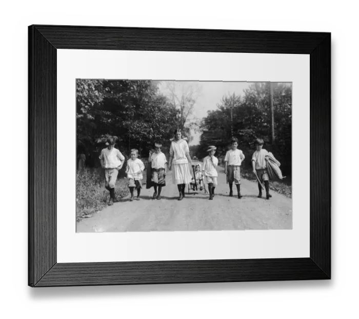 Framed Print : Country Walk; group of seven children walking in a row, and an eighth being pulled in a cart