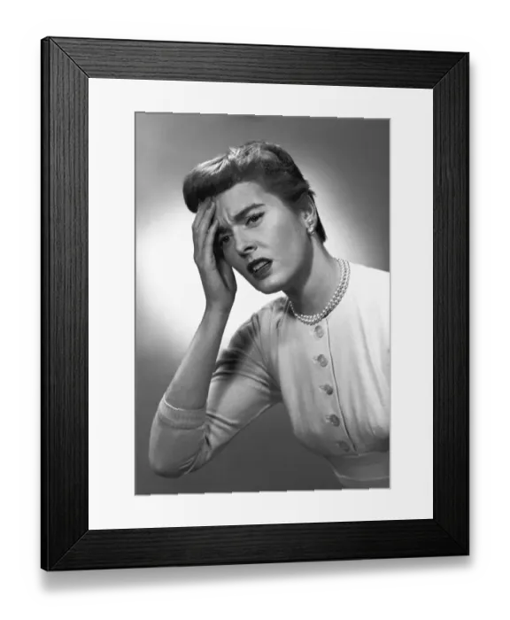Framed Print : Woman touching forehead in studio, (B&W) Framed Print : Woman touching forehead in studio, (B&W)