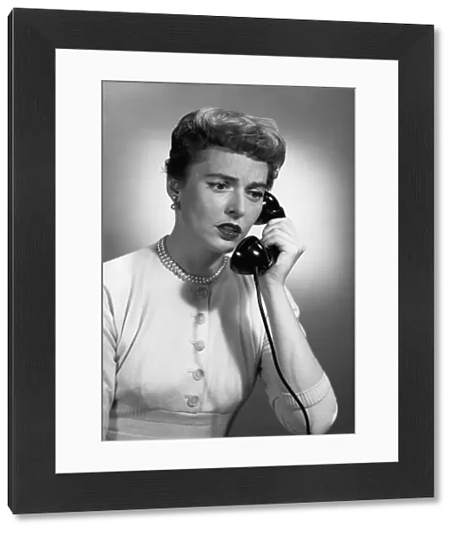 Woman talking on phone in studio, (B&W)