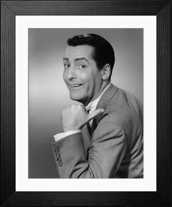 Framed Print : Smiling man pointing in studio, (B&W), portrait Framed Print : Smiling man pointing in studio, (B&W), portrait