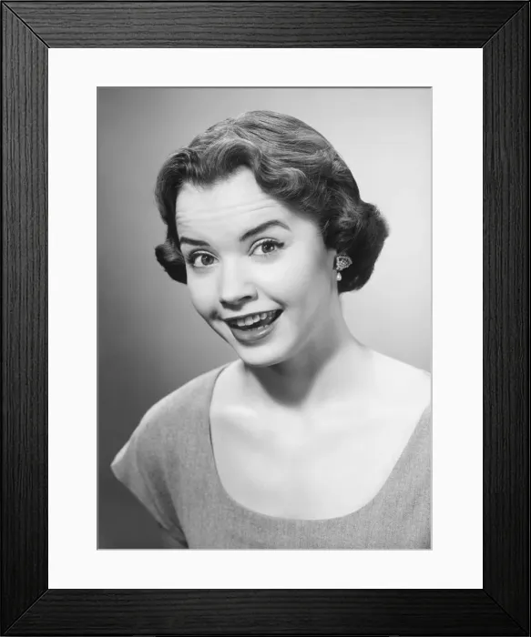 Framed Print : Smiling woman posing in studio, (B&W), portrait Framed Print : Smiling woman posing in studio, (B&W), portrait