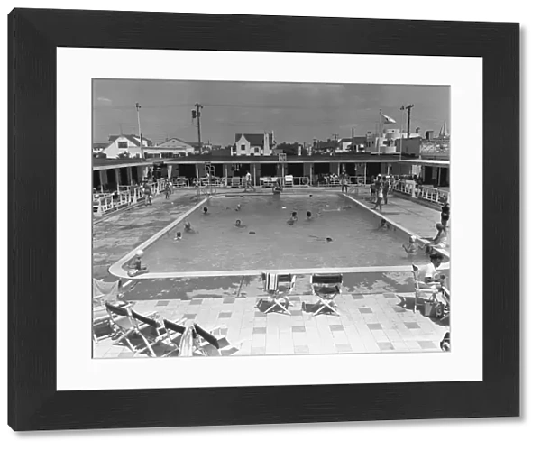 People swimming in pool, (B&W), elevated view