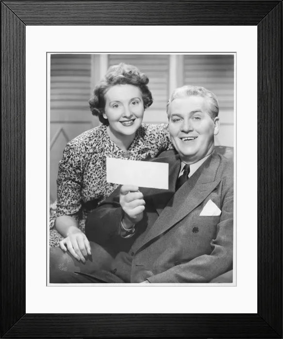 Framed Print : Mature couple posing, man holding check, (B&W), portrait Framed Print : Mature couple posing, man holding check, (B&W), portrait