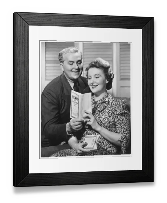 Framed Print : Mature couple looking at brochure, (B&W) Framed Print : Mature couple looking at brochure, (B&W)