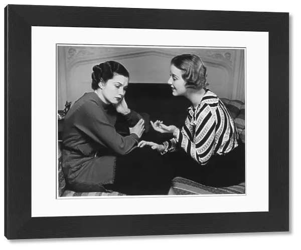 Woman consoling friend at fireplace, (B&W)