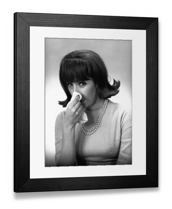 Framed Print : Woman blowing nose in studio, (B&W) Framed Print : Woman blowing nose in studio, (B&W)