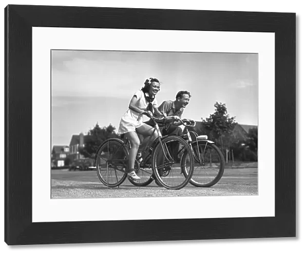 Man and woman riding bicycles, (B&W)