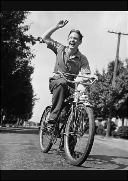 Man riding bicycle, waving, (B&W)