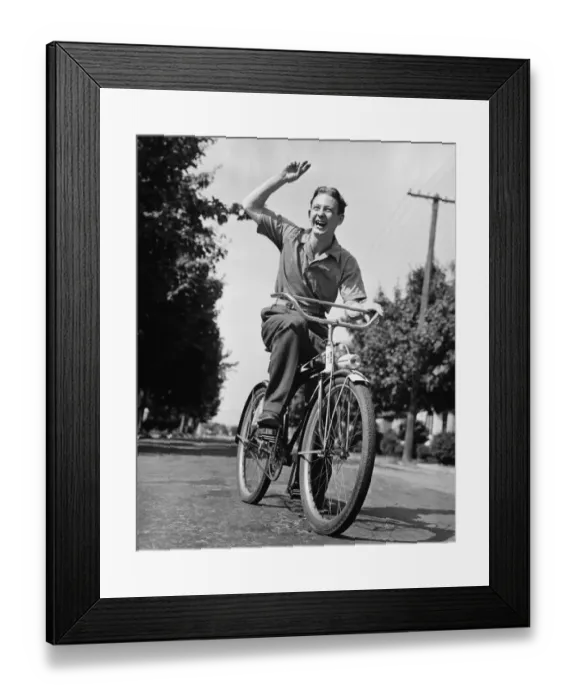 Framed Print : Man riding bicycle, waving, (B&W) Framed Print : Man riding bicycle, waving, (B&W)