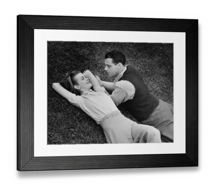 Framed Print : Romantic couple lying on grass, (B&W), elevated view