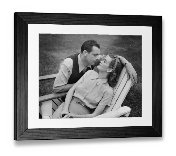 Framed Print : Romantic couple relaxing on deckchair, (B&W) Framed Print : Romantic couple relaxing on deckchair, (B&W)