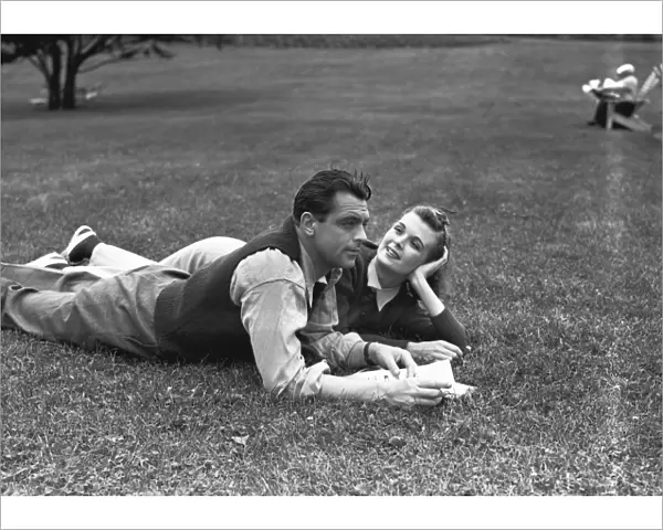 Couple lying on grass, (B&W)