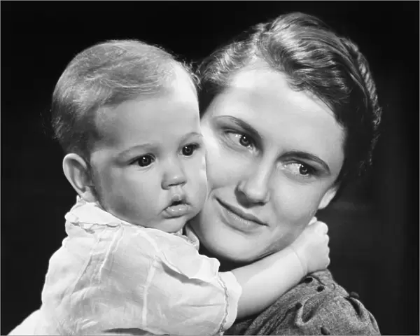 Mother with baby girl (9-12 months) posing in studio, (B&W), portrait