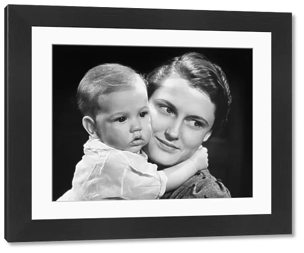 Mother with baby girl (9-12 months) posing in studio, (B&W), portrait
