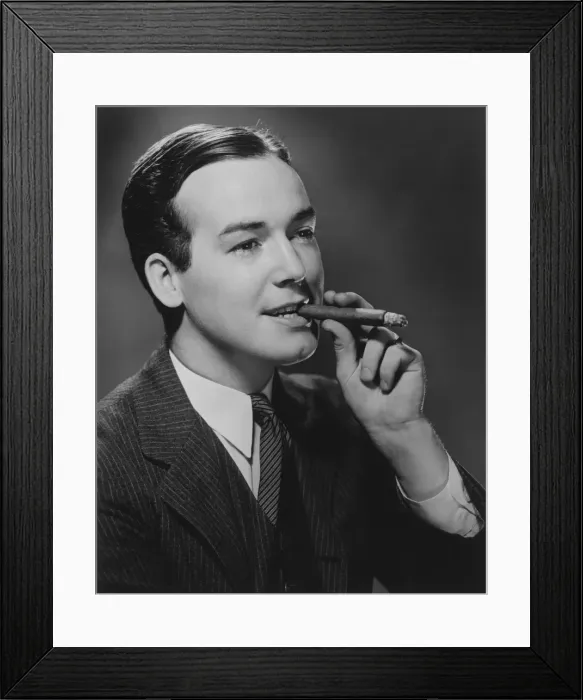 Framed Print : Man smoking cigar in studio, (B&W), portrait Framed Print : Man smoking cigar in studio, (B&W), portrait