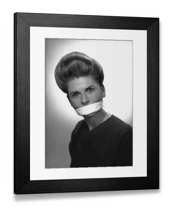 Framed Print : Woman with covered mouth in studio, (B&W), portrait Framed Print : Woman with covered mouth in studio, (B&W), portrait