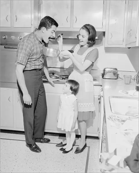 Family with daughter (2-3) preparing food in kitchen
