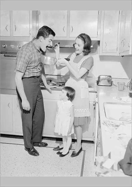 Family with daughter (2-3) preparing food in kitchen