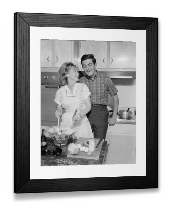 Framed Print : Mid adult couple in kitchen, woman preparing salad
