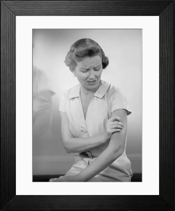 Framed Print : Woman massaging arm Framed Print : Woman massaging arm